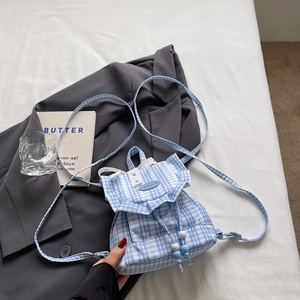 Blue plaid canvas drawstring backpack with lace trim and Fashion label on gray background