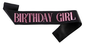 Detail of black satin Birthday Girl sash with vibrant pink lettering for party decor