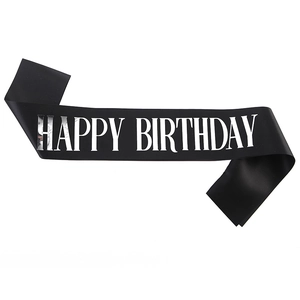Close-up of black satin birthday sash with metallic silver Happy Birthday lettering