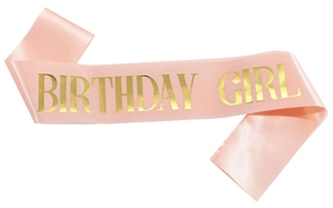 Detail of pink satin birthday girl sash with elegant gold foil lettering for party