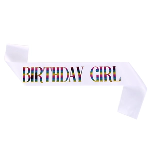 Close-up of white satin birthday girl sash featuring vibrant rainbow foil lettering
