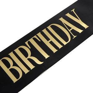 Close-up of black satin birthday sash featuring premium gold foil stamped lettering