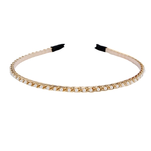 Elegant gold metal chain headband with white pearls on a clean white background