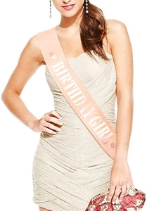 Detail of BIRTHDAY GIRL satin sash in peach pink with white lettering and crown icons