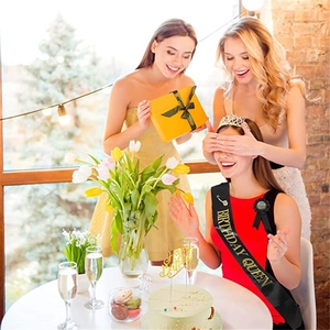 Close-up of Birthday Queen black gold sash, sparkling tiara, and party badge set