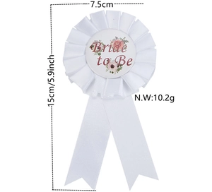 Close-up of white satin Bride to Be rosette badge with floral print and size details