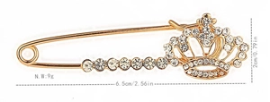 Macro shot of gold-plated crown brooch with dimensions 6.5cm length and rhinestones
