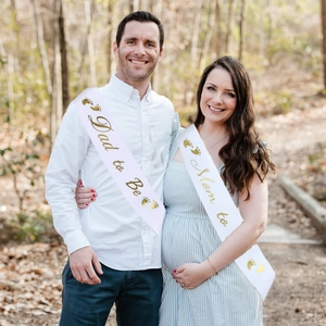 Outdoor shot of Mom to Be and Dad to Be white satin sashes with gold foil lettering