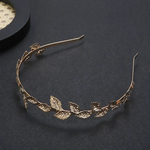Golden Greek leaf headband with baroque laurel design on a textured black background