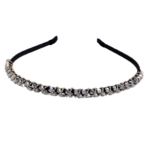 Detail of handmade rhinestone beads and gold chain wrapped on a slim black metal headband