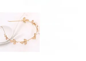 Detailed close-up of golden alloy leaf headband with intricate branch texture