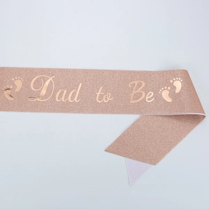 Rose gold glitter Dad to Be sash for baby showers with black lettering and footprints