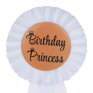 Dettaglio della coccarda Birthday Princess champagne con nastro a pieghe e logo corona