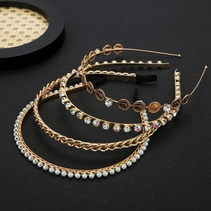 Set of four gold metal headbands with pearls, rhinestones, and vintage coin charms