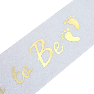 Close-up of lavender glitter Mommy to Be sash with gold foil lettering and footprints