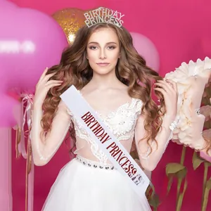 Close-up of sparkling rhinestone birthday princess crown and elegant satin sash set