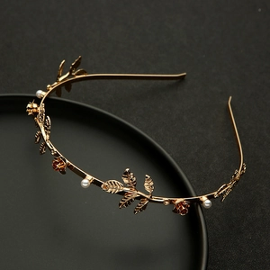 Detail of gold metal headband with pearls, rose flowers and delicate leaves