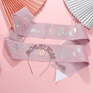 Close-up of pink glitter Mommy to Be sash and metal headband for baby shower party