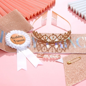 Dettaglio del set compleanno oro rosa con diadema, fascia e spilla su sfondo rosa