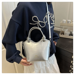 Detail of silver metallic bucket bag showing its compact shape and stylish shoulder strap