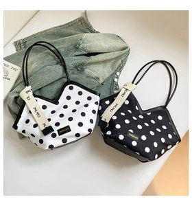 Détail de sacs fourre-tout à pois avec ouverture en V et rubans décoratifs élégants