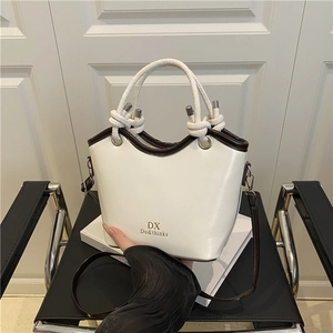 Minimalist cream white bucket bag with dark brown straps and stylish knot handle design