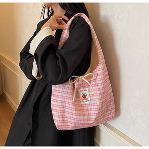 Dettaglio della borsa tote in tela a quadretti rosa e blu con fiocco e patch pomodoro