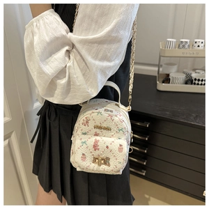 Détail du mini sac à dos blanc avec imprimés lapin rose et chaîne dorée