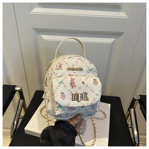 Detail of white backpack featuring cute cartoon prints and metal chain strap