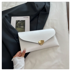 Vue détaillée de la pochette enveloppe blanche avec boucle dorée sur fond texturé