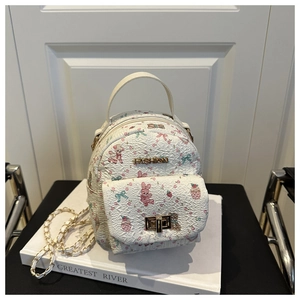 Detail of white quilted handbag with pink bunny print and gold metal fashion logo