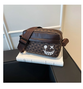 Detail view of a brown vintage geometric crossbody bag with a white graffiti smiley face
