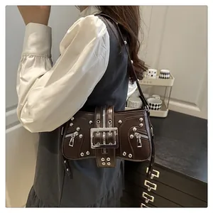 Detail view of dark brown moto-style underarm bag with silver rivets and buckle