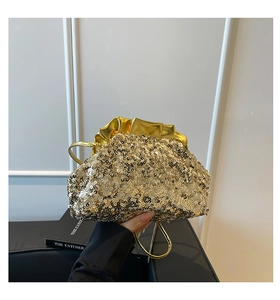 Gros plan sur un sac de soirée à paillettes dorées avec fermeture plissée métallique