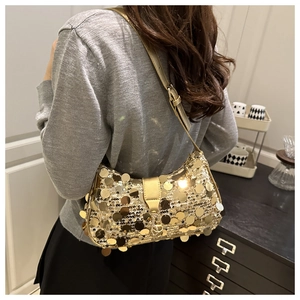 Detailed view of large gold sequins on a trendy shoulder bag with metallic texture
