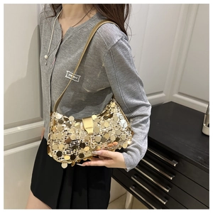 Detail of trendy underarm bag with dense gold circular sequins and sleek metallic buckle