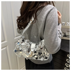 Detail showing shiny silver large sequins and thin shoulder strap on this stylish baguette bag