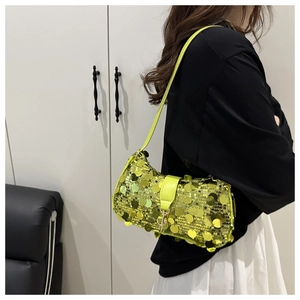 Detail of neon green shoulder bag with large reflective round sequins and leather strap