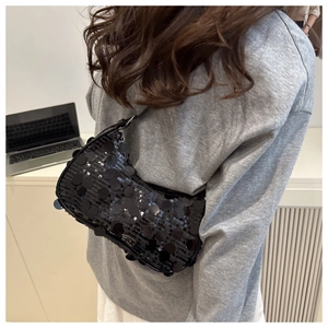 Detail of a chic black sequin crescent shoulder bag with shimmering textured finish