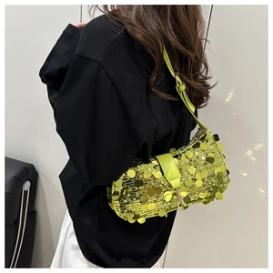 Macro detail of the fluorescent green sequins and leather strap with metal letter pendant