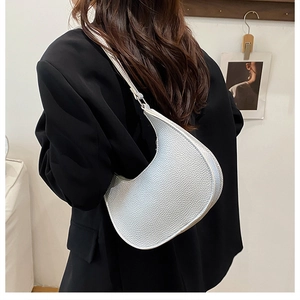 Silver crescent shoulder bag with litchi texture shown on a black blazer outfit