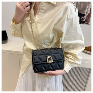 Détail d'un sac à bandoulière matelassé noir avec fermoir fer à cheval doré chic