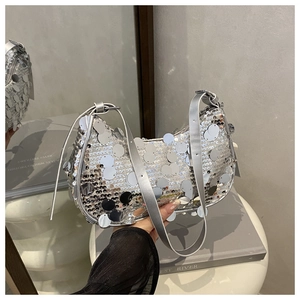 Close-up of sparkling silver sequins and premium leather strap on a stylish hobo bag