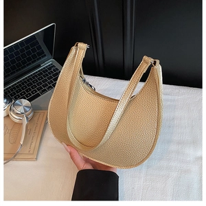 Detailed texture of champagne gold lychee leather handbag with silver metal zipper closure