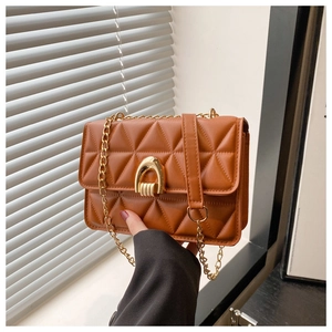 Détail du sac matelassé marron en similicuir avec boucle fer à cheval et chaîne dorée