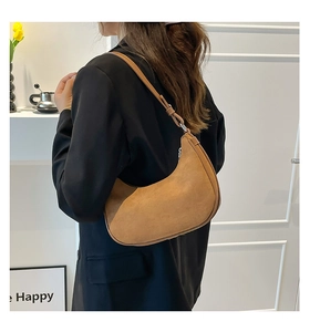 Detail of the soft brown suede hobo bag showing the crescent shape and shoulder strap