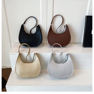 Litchi pattern crossbody bags in black, brown, silver and gold on a white display stand