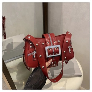 Detail of burgundy motorcycle shoulder bag with silver rivets and metal buckle hardware