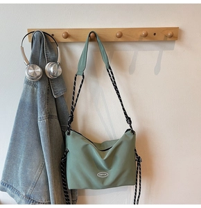Detail of grey-green nylon crossbody bag with GAIFYUN logo and braided cord strap