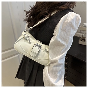 Close-up of a white glossy underarm bag with silver buckles and eyelet straps